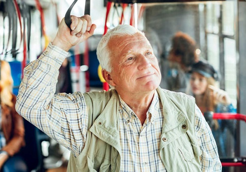 Senior man on a bus with hearing aids
